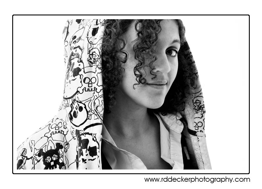 Senior in a hoodie against white seamless background.